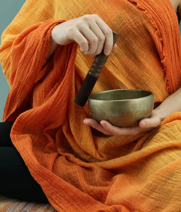A person sitting in a focused meditation pose with a bronze color theme.
